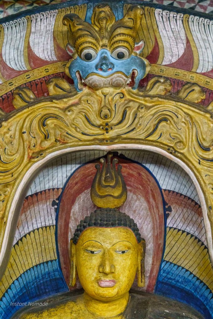 detail d'un bouddha avec une tete de dragon qui le surplombe au temple d'or de dambulla